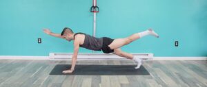 Dr. Jon in a high plank position doing the plank superman exercise with his right arm lifted infront and his left leg extended behind